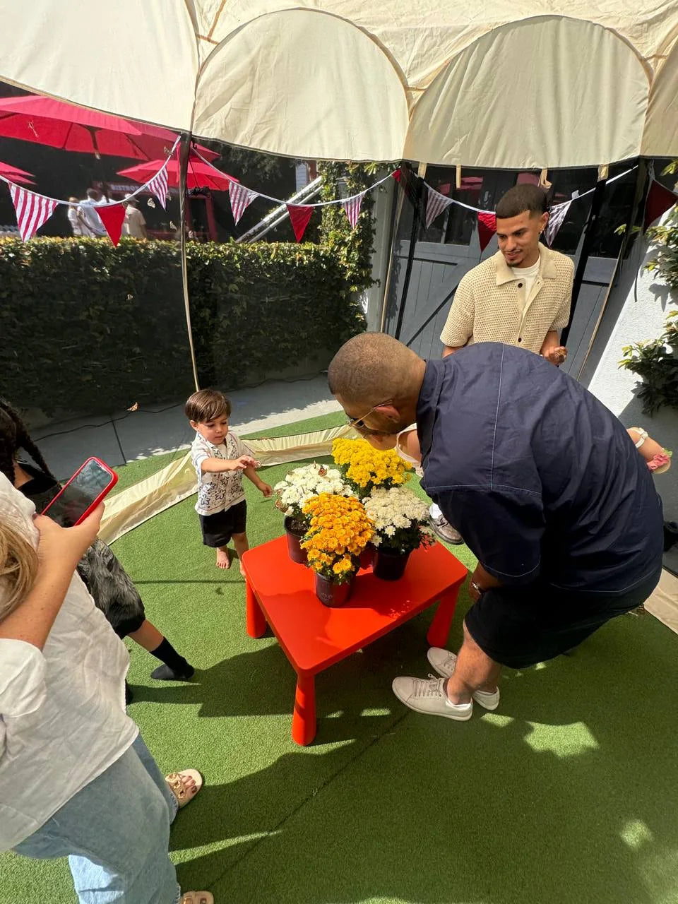A family gathers around the flower table inside the walk-in dome